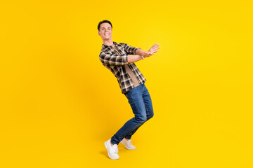 Fototapeta na wymiar Photo of crazy hipster funny guy dance modern move wear plaid shirt jeans shoes isolated yellow color background