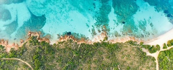 View from above, stunning aerial view of a green and rocky coastline bathed by a turquoise, crystal clear water. Liscia Ruja, Costa Smeralda, Sardinia, Italy..