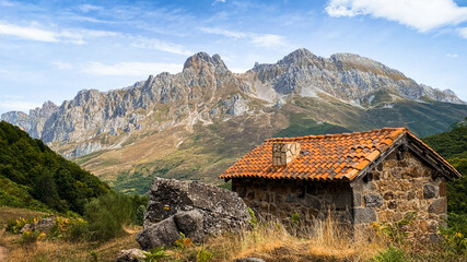 Fototapeta na wymiar Mountain cabin with high and beautiful mountains in the background. Majada de Brez, Picos de Europa