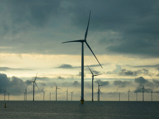 Fryslân wind farm in the Frisian part of the IJsselmeer, near the dike. The offshore wind farm is completely located in the IJsselmeer, Breezanddijk. Sky with storm and rain clouds. Space for text.