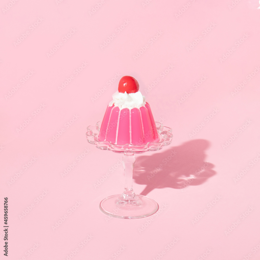 Wall mural pink jello on dish with cherry on top on pastel pink background. 70s or 80s retro style aesthetic de