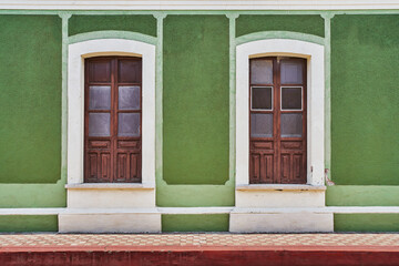 Rustic green colored facade with an antique wooden village window