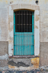 Fototapeta na wymiar Sky blue facade with a chocolate colored wooden window on a frame