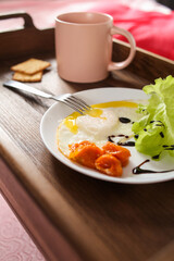 Breakfast in bed - scrambled eggs and salad with a cup of tea and biscuits. On a tray - table
