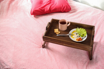 Breakfast in bed - scrambled eggs and salad with a cup of tea and biscuits. On a tray - table
