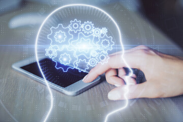 Double exposure of brain sketch hologram and woman holding and using a mobile device.
