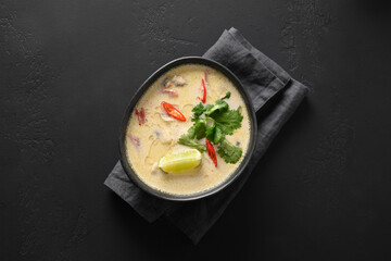 Asian Tom Kha Gai soup with chicken, cherry tomato, coconut milk, kaffir, galangal, lemongrass, mushrooms. Thai food. Coconut Chicken Soup. View from above.