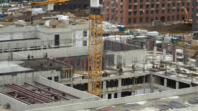 Time lapse of workers pour and level concrete, work with steel concrete reinforcement on background of large construction site. Сonstruction industry