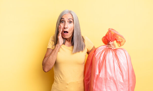 middle age pretty woman feeling shocked and scared. plastic garbaje bag