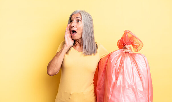 middle age pretty woman feeling happy, excited and surprised. plastic garbaje bag