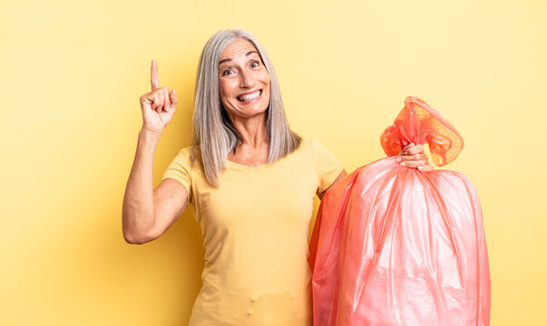 middle age pretty woman feeling like a happy and excited genius after realizing an idea. plastic garbaje bag