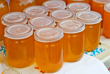 Lots of assorted honey on the table. Jars of sweets are sold at the fair.