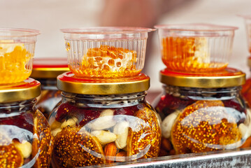 Lots of assorted honey on the table. Jars of sweets are sold at the fair.