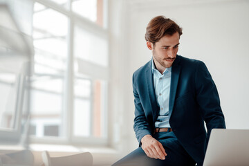 Male professional using laptop while working in office