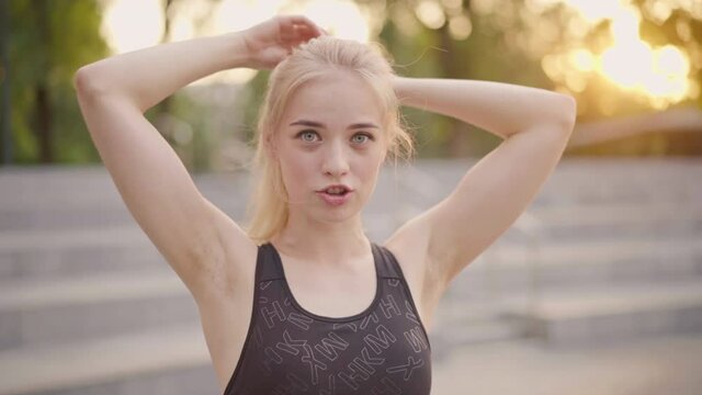 Sport and Fitness. Young Caucasian Woman tie ponytail Dressed Sportswear Standing Outdoor Summer Park Sunlight Background Resting After Training Jogging Running Exercises Close up portrait