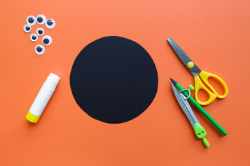 The child creates a black spider decoration. Halloween party. Children's art project. DIY concept....