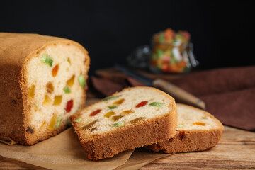 Delicious cake with candied fruits on wooden table, closeup