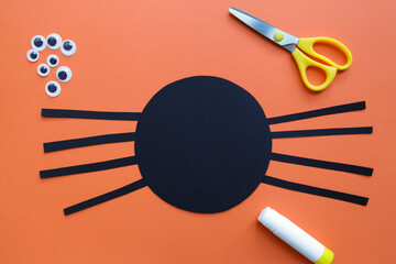 The child creates a black spider decoration. Halloween party. Children's art project. DIY concept. Step-by-step photo instruction. Step 4