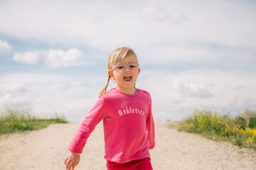 little girl with glasses running