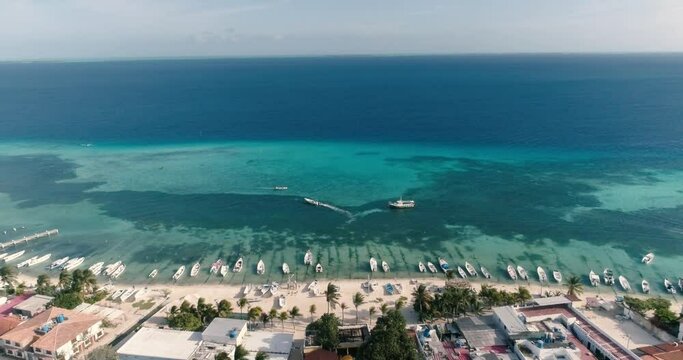 Aerial Landscape  Caribbean beach town. Pan rigth  over island along Shore beach. Fisherman boats moored.  Location Gran Roque Venezuela