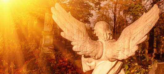 An ancient statue of angel in the cemetery as symbol of death, pain and end of life. Horizontal...