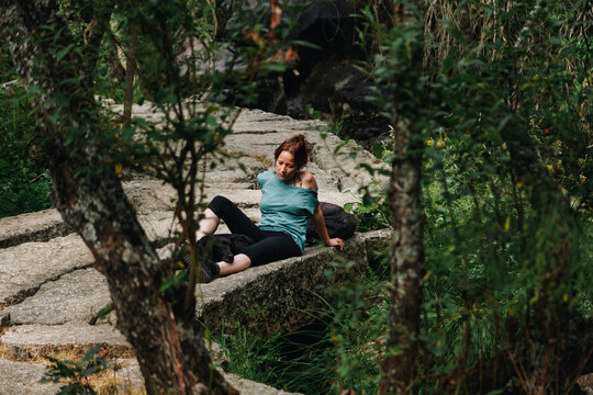 Mid adult woman and dog relaxing in forest during weekend