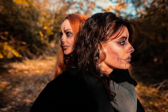 Friends with spooky make-up in forest during Halloween