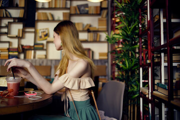 beautiful woman sitting at a table with a drink in a cafe Lifestyle