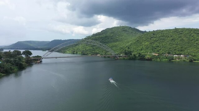 Aerial Adome bridge boat Volta River Ghana Africa. River system in  West African country of Ghana. Adome Bridge crosses the river. Akosombo Dam forms largest manmade lake by area in the world.