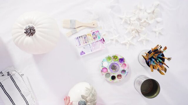 Flat lay. Step by step. Painting craft pumpkin with acrylic paint to create decorated mermaid Halloween pumpkin.