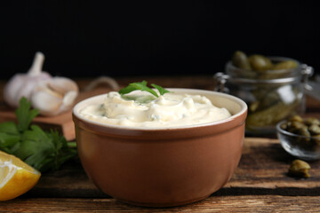 Tasty tartar sauce and ingredients on table, closeup