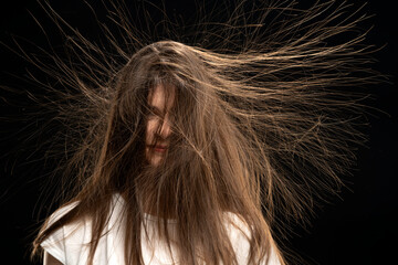 Woman with long static hair up, isolated on black background. 