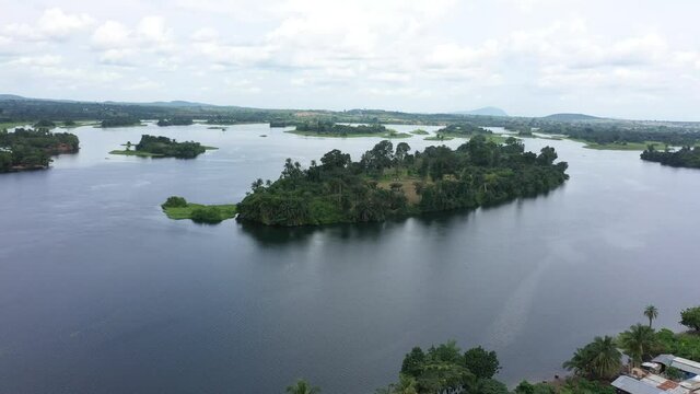 Aerial Adome village Volta river island Ghana Africa. Main river system in West African country of Ghana. Akosombo dam generating hydroelectricity. Largest man made reservoir by area in the world.