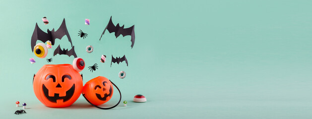 Happy Halloween day banner with cute pumpkins, flying paper cut bats, sweets and spiders against light blue with empty space for text.