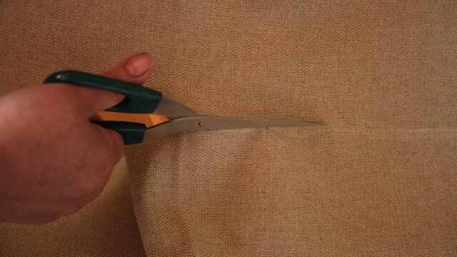 Close-up scissors cut textile at home. Hand with scissors cut the tulle. Copy space for text in textile store. Tailor, dressmaker, sewing work concept. Needling Equipment, Textile, Fine Cloth.
