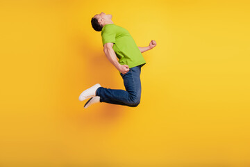 Fototapeta na wymiar Portrait of crazy astonsihed sportive guy jump have fun on yellow wall