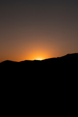 Obraz premium Beautiful sunset captured just as the last ray of sunlight was hiding behind this dense mountain creating a totally mesmerizing play of light and shadow.