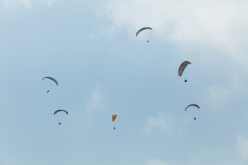 Six paragliders in multicoloured parachutes, Pokhara, Nepal