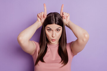 Beautiful young woman wearing casual t-shirt doing funny gesture with finger over head as bull...
