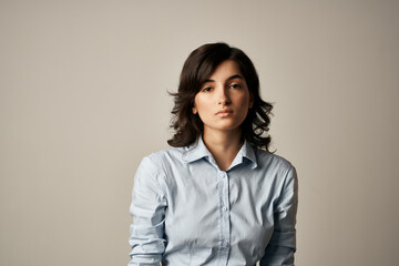 brunette in blue shirt cropped view light background elegant style