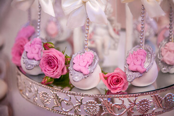 Delicious desserts at the wedding candy bar in the buffet area: cake pops decorated with angels and cameo and fresh rosebuds