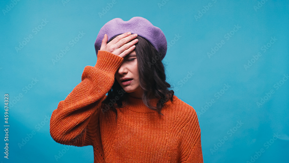 Canvas Prints upset woman in beret showing facepalm gesture isolated on blue