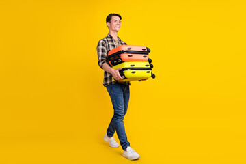 Fototapeta na wymiar Profile photo of delivery guy carry pile cases walk wear checkered shirt jeans sneakers isolated yellow color background