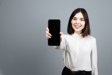 Girl with a phone. Asian woman smiling. shows phone