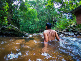 man relaxing in natural waterfall at green forests from different angle