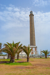 Maspalomas, Las Palmas, Spain, 17.09.2021: Landmark 1890s lighthouse, a popular place to watch the sunset, with a beach, shops and bars nearby.
