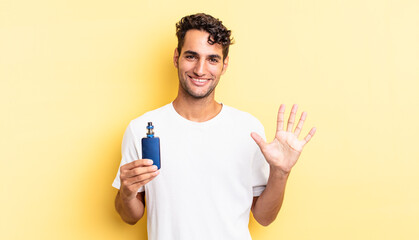 hispanic handsome man smiling and looking friendly, showing number five. vaporizer concept