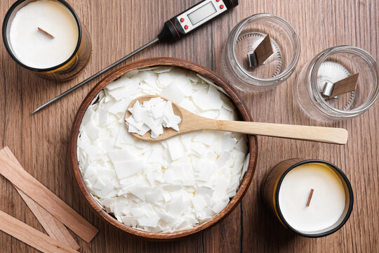 Flat lay composition with homemade candles  and ingredients on wooden background