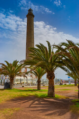 Maspalomas, Las Palmas, Spain, 17.09.2021: Landmark 1890s lighthouse, a popular place to watch the sunset, with a beach, shops and bars nearby.