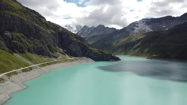 the beautifully shining lac de moiry from a bird's eye view, beautifully situated in the middle of the Swiss Alps in the canton of valais